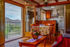 a kitchen and dining room with a table and a balcony at La Casa del Carrebaix in Orba