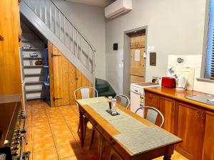 a kitchen with a table and a kitchen with a staircase at Whites Corner in Bothwell