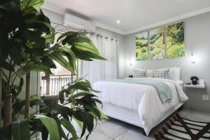 a bedroom with a white bed and a window at African Sands Guesthouse in Bloemfontein