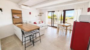 a kitchen and living room with a table and a couch at Rena Bianca Residence 201 in Baja Sardinia