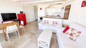 a living room with a white couch and a table at Rena Bianca Residence 201 in Baja Sardinia