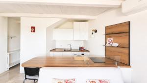 a kitchen with a wooden table and a sink at Rena Bianca Residence 201 in Baja Sardinia