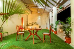a room with a table and chairs and plants at Bairava Bliss Inn - Rameswaram in Rāmeswaram