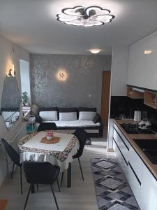 a living room with a table and a kitchen at Kamienica Senator in Skierniewice +17 photos