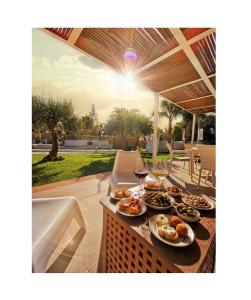 a table with plates of food and glasses of wine at Villa Sunset B&B/Apartments in Fontane Bianche