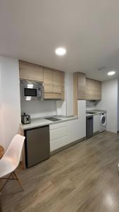 a kitchen with wooden cabinets and a table and a chair at Rincón Mudejar in Teruel