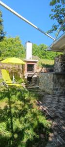 a yellow chair and an umbrella in a yard at Olive Gardens Cottage above Portorož in Strunjan