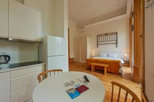 a kitchen with a table and a bed in a room at Casa da Praça by PURUS in Coimbra