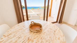 a table with a basket on it with a view of the ocean at Rena Bianca Residence 225 in Baja Sardinia