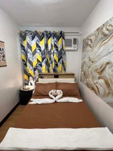 ein Schlafzimmer mit einem Bett, auf dem zwei Handtücher liegen in der Unterkunft Chyns Suite in Marilao