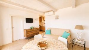 a living room with a table and a couch at Rena Bianca Residence 225 in Baja Sardinia +11 photos