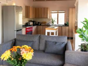 a living room with a couch with a vase of flowers at Ntoma House in Hoedspruit +6 photos