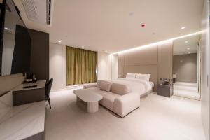 a bedroom with a white bed and a white couch at The Gleam Hotel in Incheon
