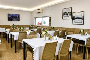 a dining room with white tables and chairs at AC Hotel in Luanda