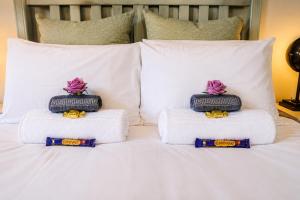 a white bed with two pillows on top of it at Rose cottage Garden Suite in Pretoria