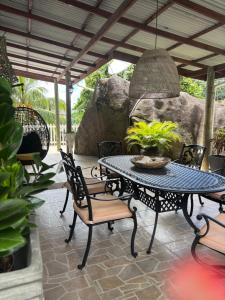 a patio with a table and chairs under a roof at Touchdown Villa in Pointe Larue