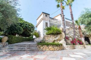 a house with palm trees and stairs in front at VILLA FRANCA in Fontane Bianche