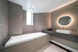 a large bathroom with a tub and a sink at The Gleam Hotel in Incheon