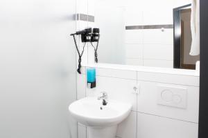 a white bathroom with a sink and a toilet at OEKOTEL Hohenems in Hohenems +20 photos