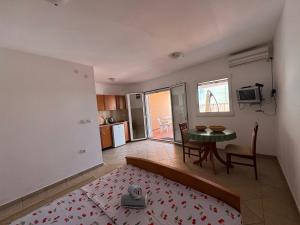 a room with a bed and a table and a kitchen at SS Pearl Apartment in Utjeha