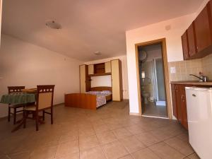 a kitchen with a table and a bedroom with a bed at SS Pearl Apartment in Utjeha