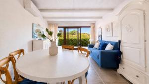 a living room with a table and a blue couch at Rena Bianca Residence 241 in Arzachena