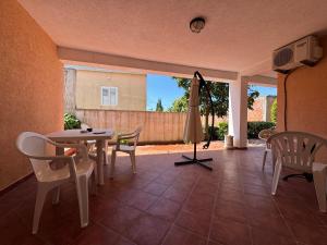 a patio with a table and chairs and an umbrella at SS Pearl Apartment in Utjeha