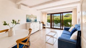 a living room with a blue couch and a table at Rena Bianca Residence 241 in Arzachena