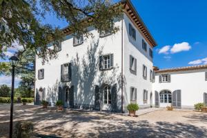 a large white building with a courtyard at ANTICA VILLA MERELLI 12, Emma Villas in Monte San Savino