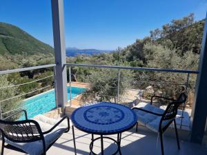 a balcony with a table and chairs and a pool at Villa Maya Lefkada in Évyiros