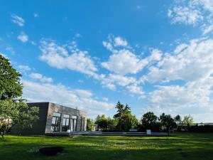 a building on a grass field with a blue sky at Gutshaus Wohnung 5 in Laschendorf