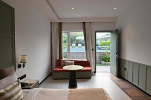 a bedroom with a bed and a table and a couch at Status Club Resort in Kānpur +26 photos