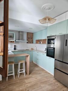 a kitchen with blue cabinets and a table with stools at La Bohème in Antequera