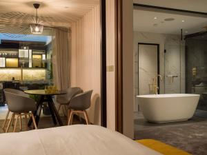 ein Schlafzimmer mit Badewanne, Tisch und Stühlen in der Unterkunft Middle Eight - Covent Garden in London + 54 Fotos