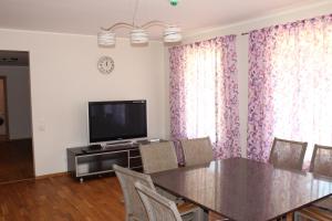 a dining room with a table and a television at Kuru Villa in Kuru