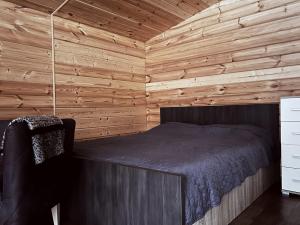 a bedroom with a bed in a wooden cabin at Trobelė miške in Palazdžiai