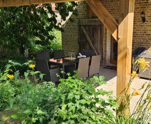 a patio with a table and chairs in a garden at Ferienhaus Pathe in Neuendorf bei Wendisch Buchholz