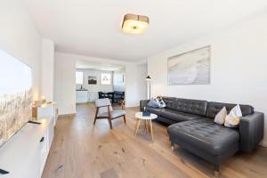 a living room with a black leather couch at Appartementanlage Wieben in Böhl