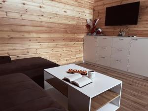 a living room with a coffee table and a tv at Trobelė miške in Palazdžiai