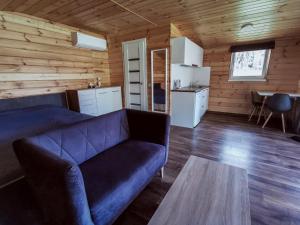 a living room with a blue couch and a table at Trobelė miške in Palazdžiai