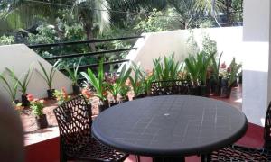 a black table and chairs on a balcony with plants at Green Haven Villas in Chennai