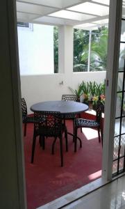 a table and chairs in a room with a patio at Green Haven Villas in Chennai