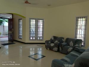 a living room with two chairs and a couch at Green Haven Villas in Chennai