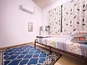 a bedroom with a bed and a blue rug at Lanang Islamic Homestay in Bedung