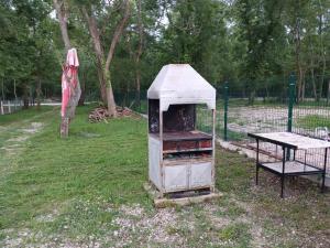 an old stove in a field next to a table at Vikendica Eldar, Ada Bojana in Ulcinj