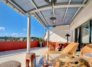 a patio with a table and chairs on a balcony at La Colombine Appart'Hôtel in Sainte Marie