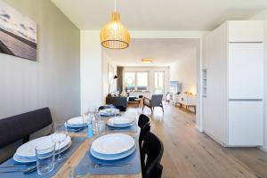 a dining room and living room with a table and chairs at Appartementanlage Wieben in Böhl