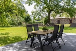 a wooden table and four chairs on a patio at Spatzenhuus in Rubkow