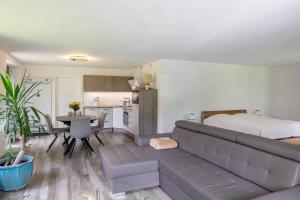 a living room with a couch and a bed at Spatzenhuus in Rubkow
