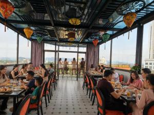 a group of people sitting at tables in a restaurant at OCEAN HOTEL Ninh Binh - Near Trang An & Hoa Lư Old Town in Kỳ Vĩ
